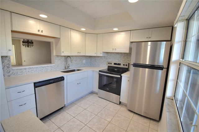 kitchen featuring white cabinetry, sink, light tile patterned floors, and stainless steel appliances