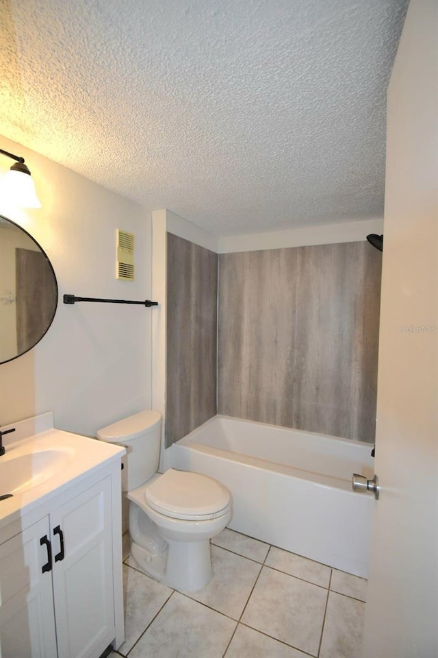 bathroom featuring tile patterned flooring, vanity, toilet, and a textured ceiling