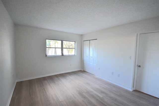 unfurnished room featuring wood-type flooring and a textured ceiling