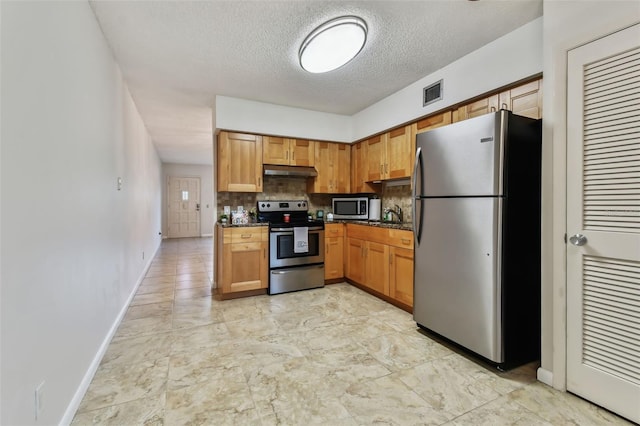 kitchen featuring a textured ceiling, backsplash, and stainless steel appliances