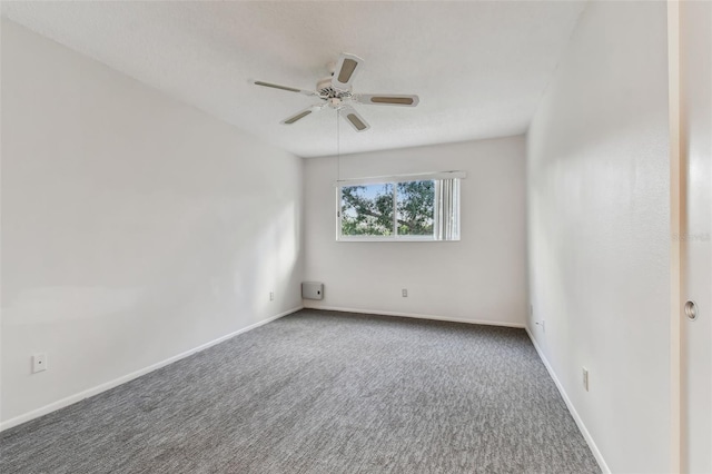 empty room with dark carpet and ceiling fan