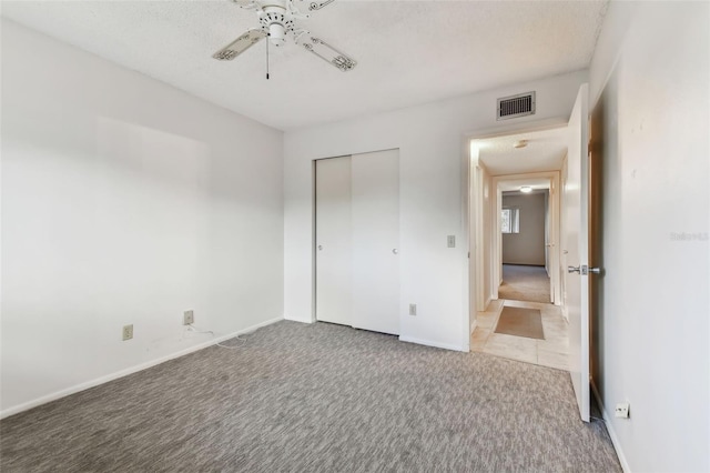 unfurnished bedroom featuring carpet flooring, a closet, and ceiling fan