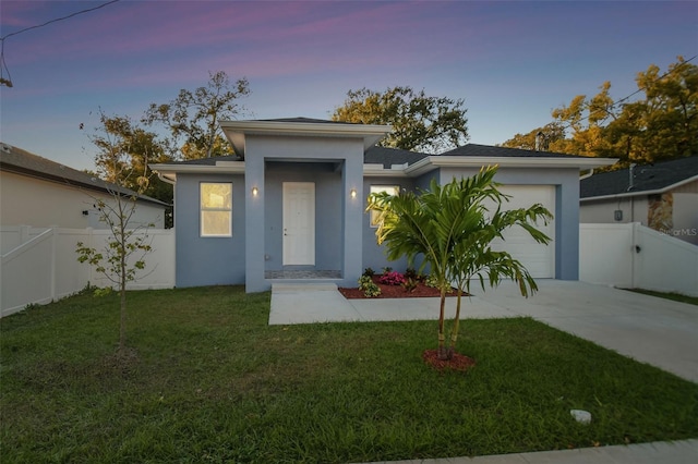 view of front of home featuring a lawn and a garage