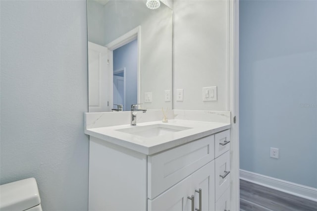 bathroom with vanity, wood-type flooring, and toilet