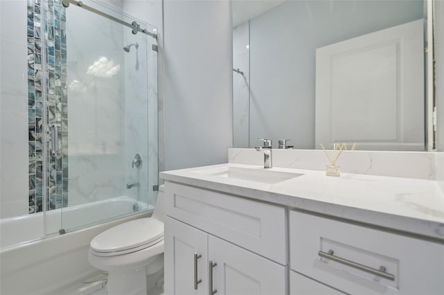 full bathroom featuring combined bath / shower with glass door, vanity, and toilet