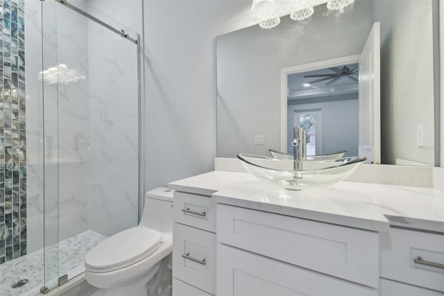 bathroom featuring ceiling fan, a shower with door, vanity, and toilet