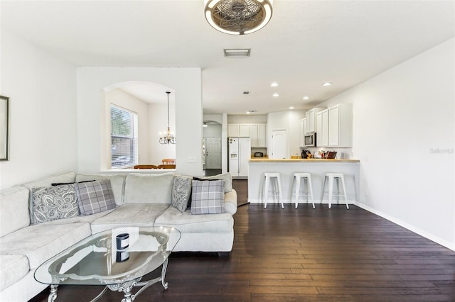 living room with dark wood-type flooring and a chandelier