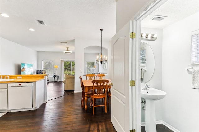 interior space featuring a textured ceiling, sink, dark hardwood / wood-style floors, and a notable chandelier