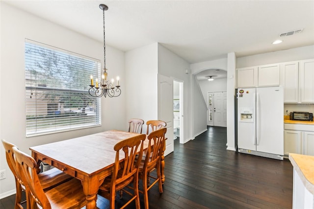 dining area featuring dark wood-type flooring and a chandelier