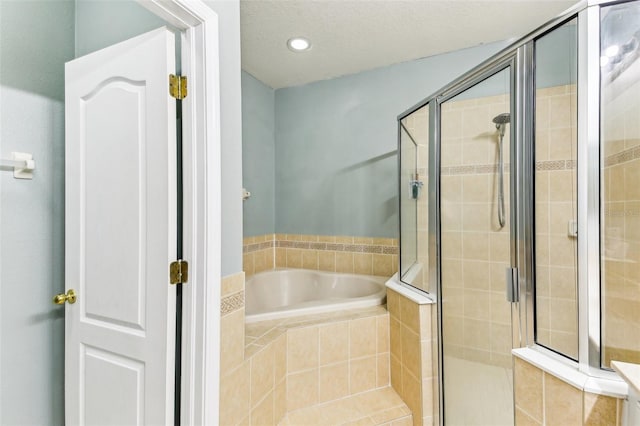 bathroom with plus walk in shower and a textured ceiling