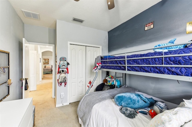 carpeted bedroom with ceiling fan and a closet