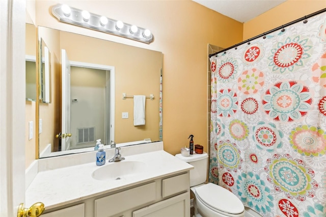 bathroom featuring curtained shower, vanity, and toilet