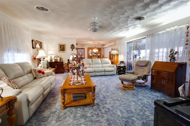 living room featuring carpet and ceiling fan with notable chandelier