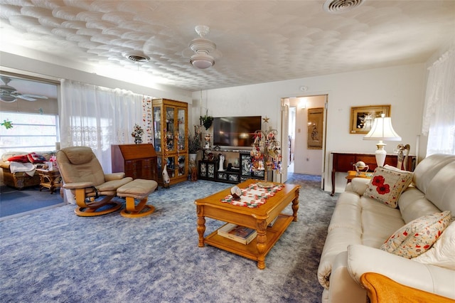 carpeted living room with ceiling fan