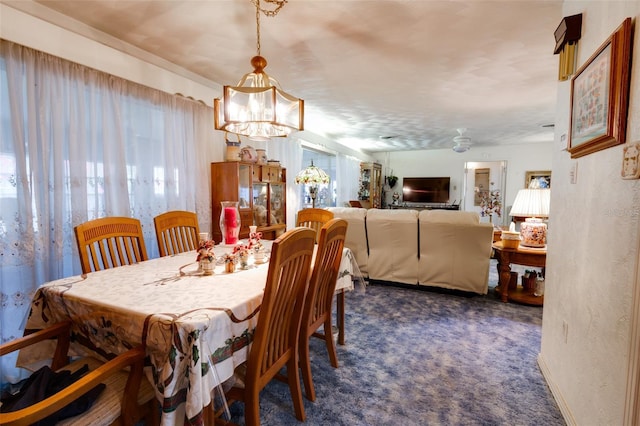 dining room featuring dark carpet, plenty of natural light, and a notable chandelier