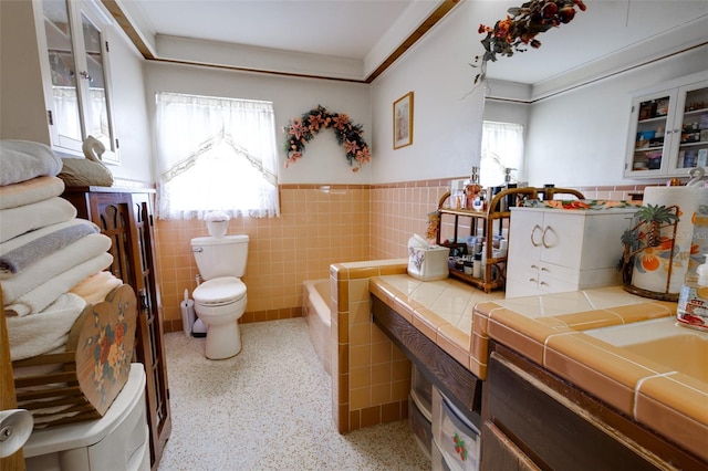 bathroom with plenty of natural light, toilet, and tile walls