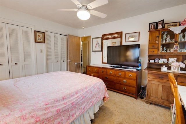 carpeted bedroom with multiple closets and ceiling fan