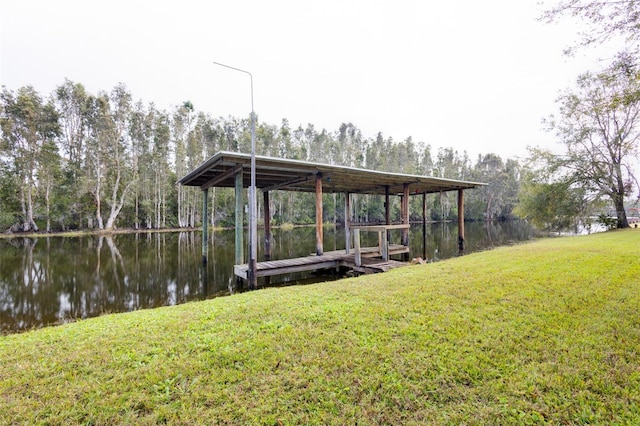 dock area with a lawn and a water view