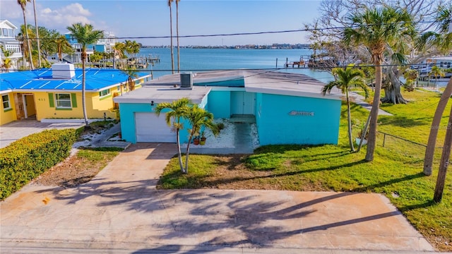 view of front of house with a front lawn, a water view, and a garage