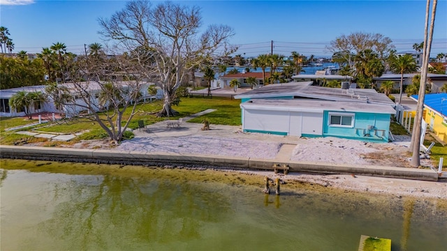 view of dock with a lawn and a water view