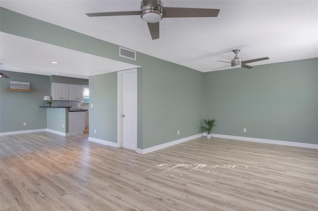 unfurnished living room with ceiling fan, light hardwood / wood-style floors, and a textured ceiling