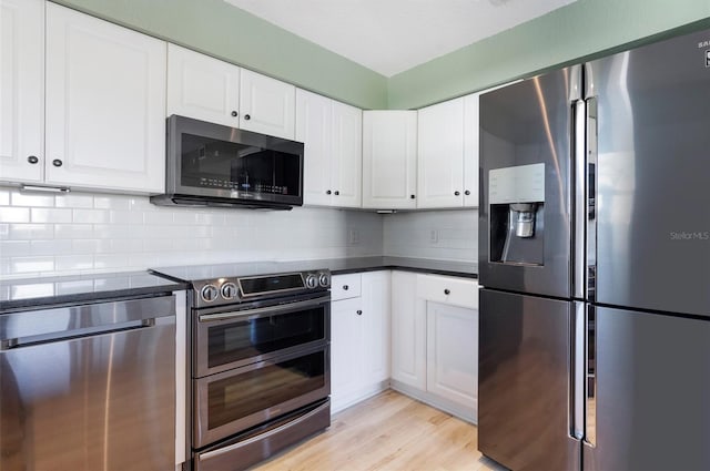 kitchen featuring backsplash, light wood-type flooring, white cabinetry, and stainless steel appliances