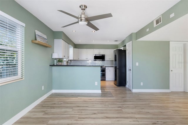 kitchen featuring white cabinets, decorative backsplash, ceiling fan, kitchen peninsula, and stainless steel appliances