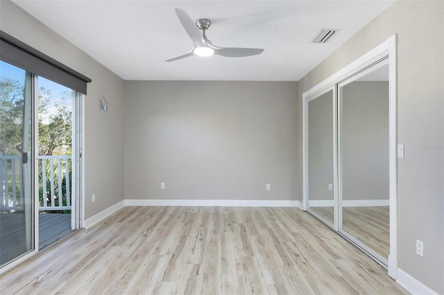 empty room with ceiling fan and light hardwood / wood-style flooring