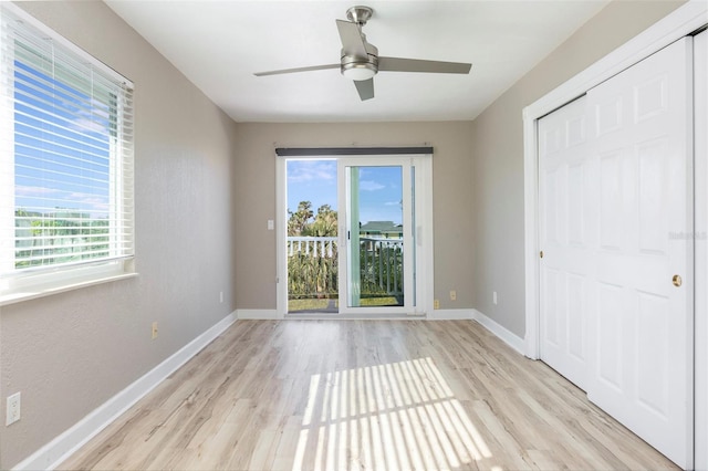 unfurnished bedroom with ceiling fan, light wood-type flooring, and a closet