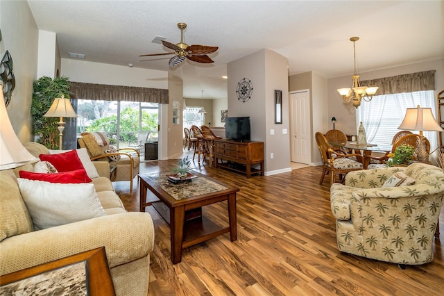 living room featuring ceiling fan with notable chandelier and hardwood / wood-style flooring