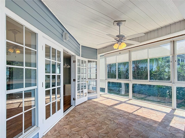 unfurnished sunroom featuring ceiling fan