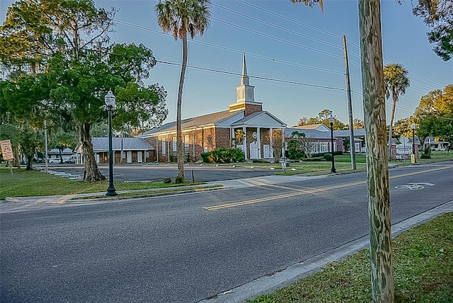 view of street with sidewalks, traffic signs, curbs, and street lights