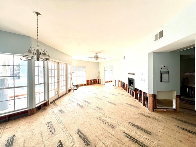 unfurnished living room featuring visible vents and ceiling fan with notable chandelier