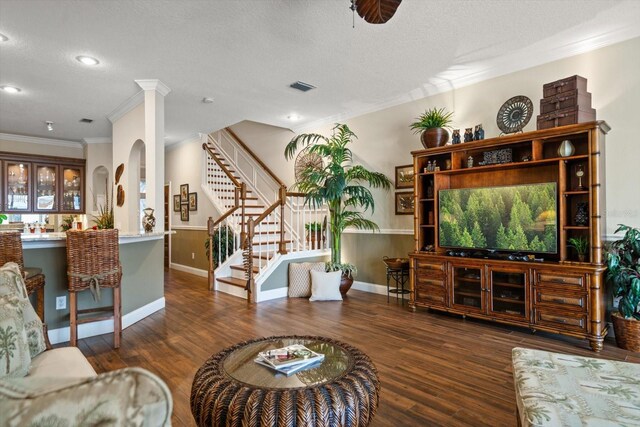 living room featuring a textured ceiling, dark wood-type flooring, and ornamental molding