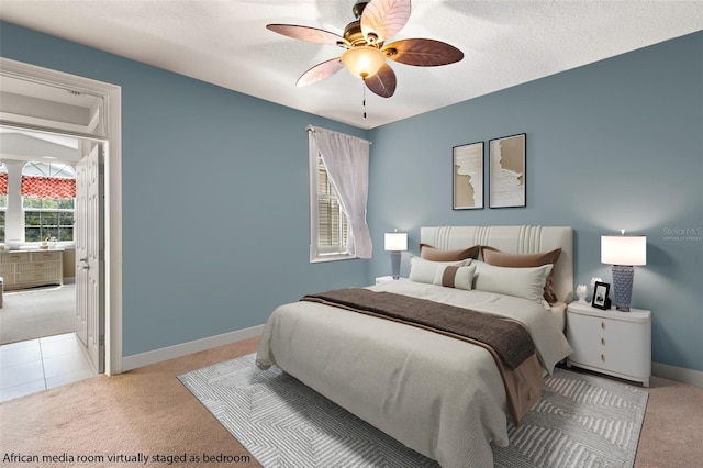 bedroom featuring light carpet, ceiling fan, and a textured ceiling