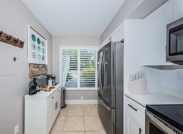 kitchen featuring white cabinets, light tile patterned floors, and stainless steel appliances