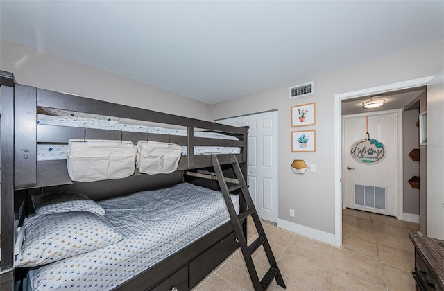 bedroom with a closet and light tile patterned flooring