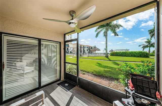 unfurnished sunroom with ceiling fan