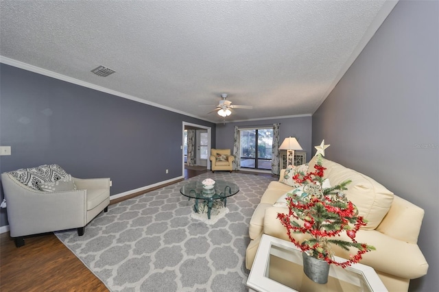 living room featuring hardwood / wood-style flooring, ceiling fan, crown molding, and a textured ceiling