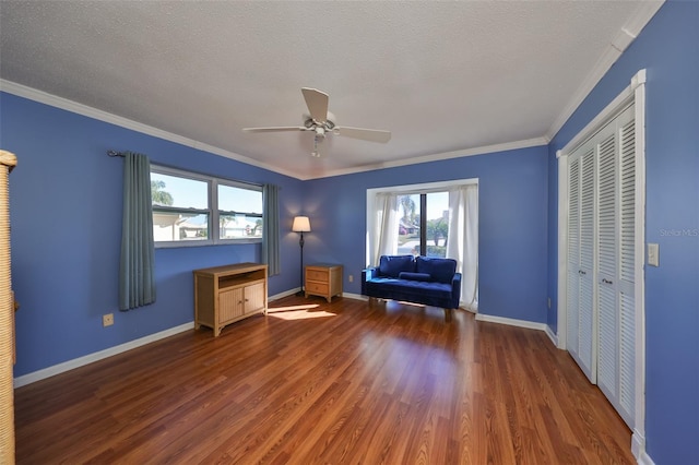 unfurnished room featuring a textured ceiling, dark hardwood / wood-style flooring, ceiling fan, and crown molding