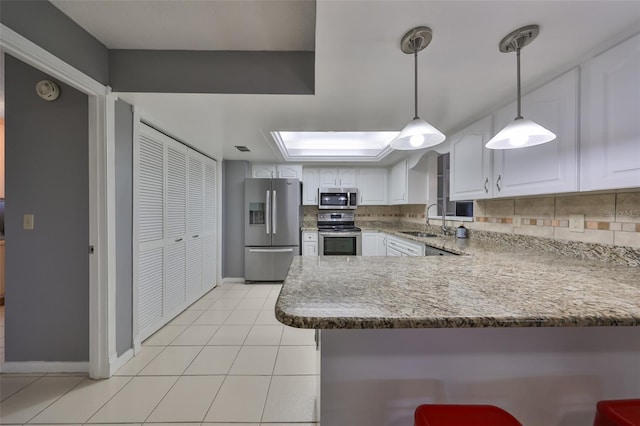 kitchen featuring white cabinets, sink, hanging light fixtures, kitchen peninsula, and stainless steel appliances