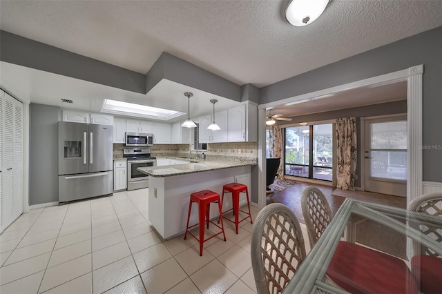 kitchen with white cabinetry, kitchen peninsula, sink, and appliances with stainless steel finishes