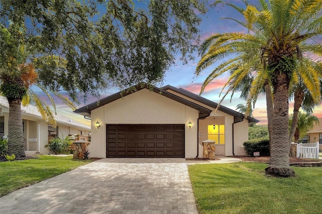 ranch-style house featuring a garage and a yard