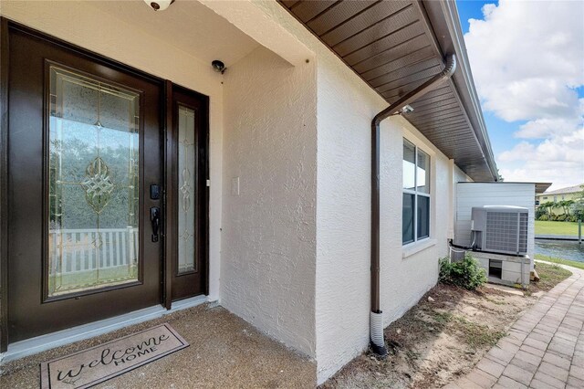 view of exterior entry featuring central AC unit