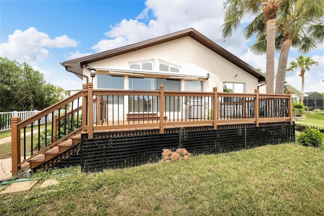 rear view of property with a yard and a deck