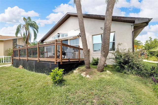 back of property featuring a yard and a deck