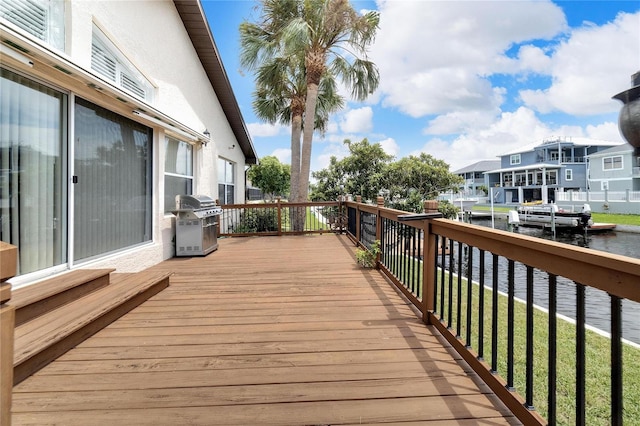 wooden terrace with a water view and area for grilling