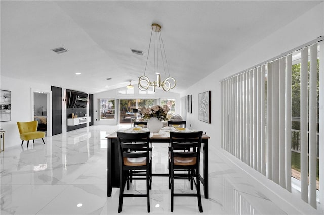 dining area with lofted ceiling and a notable chandelier