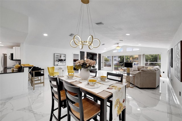 dining space featuring lofted ceiling, a notable chandelier, and a textured ceiling