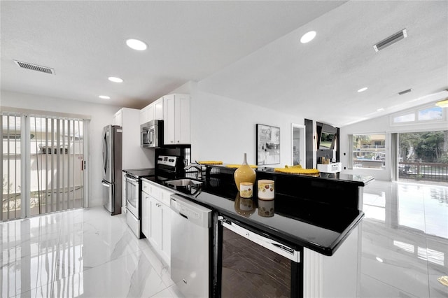 kitchen with appliances with stainless steel finishes, white cabinetry, lofted ceiling, sink, and wine cooler